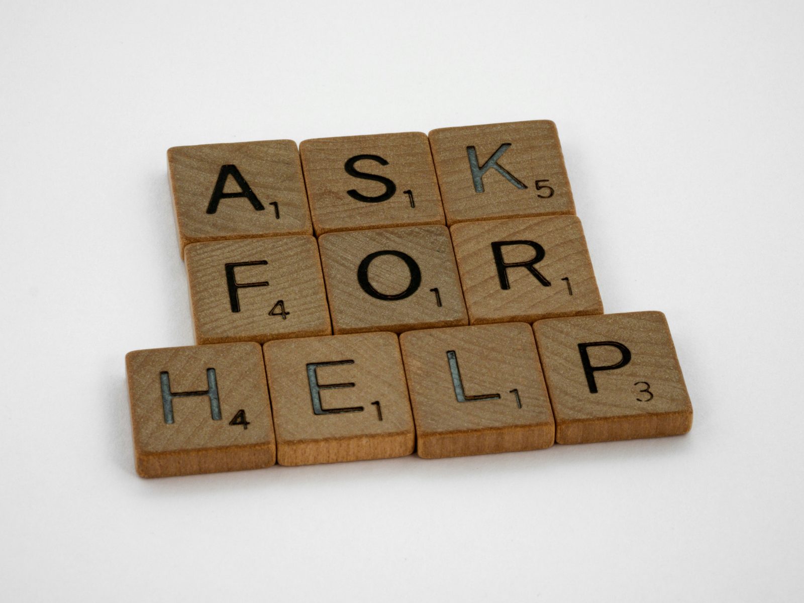 Scrabble-Steine mit dem Schriftzug „Ask for help“